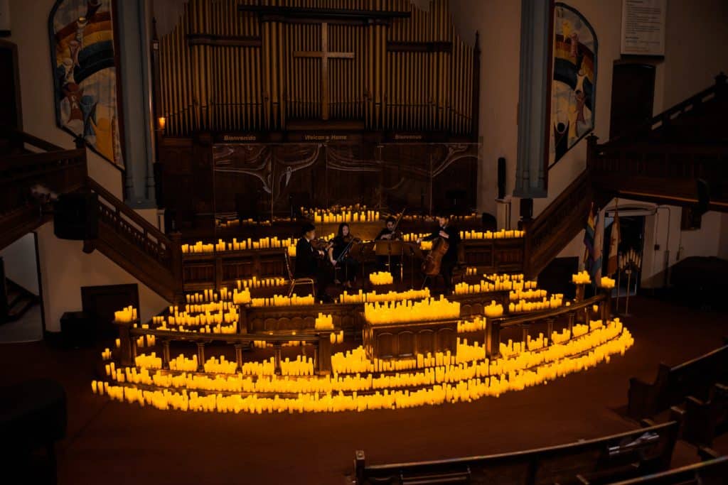 string quartet performing at candlelight concert at metropolitan church in toronto surrounded by candles