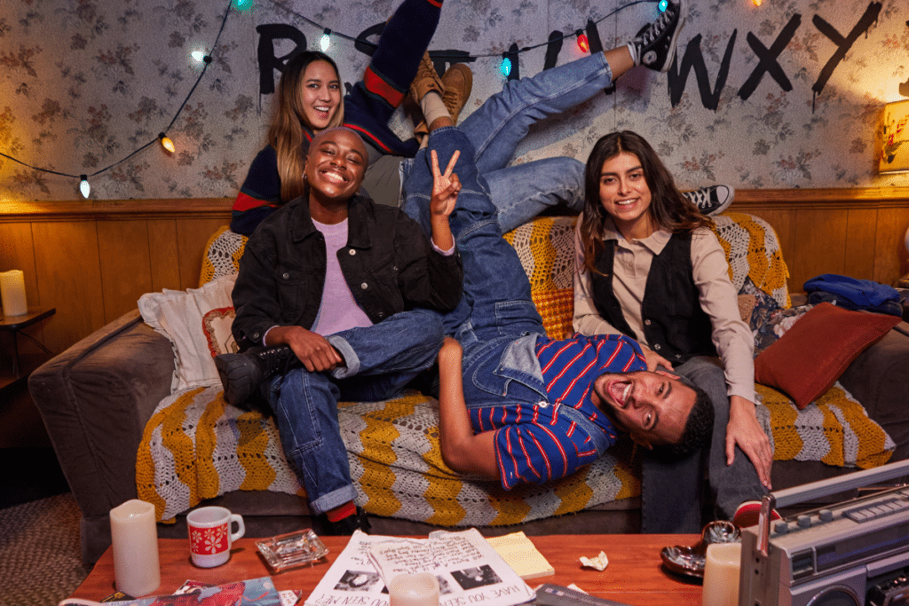 A group of people posing for a picture on a sofa at the Stranger Things Experience in Toronto.