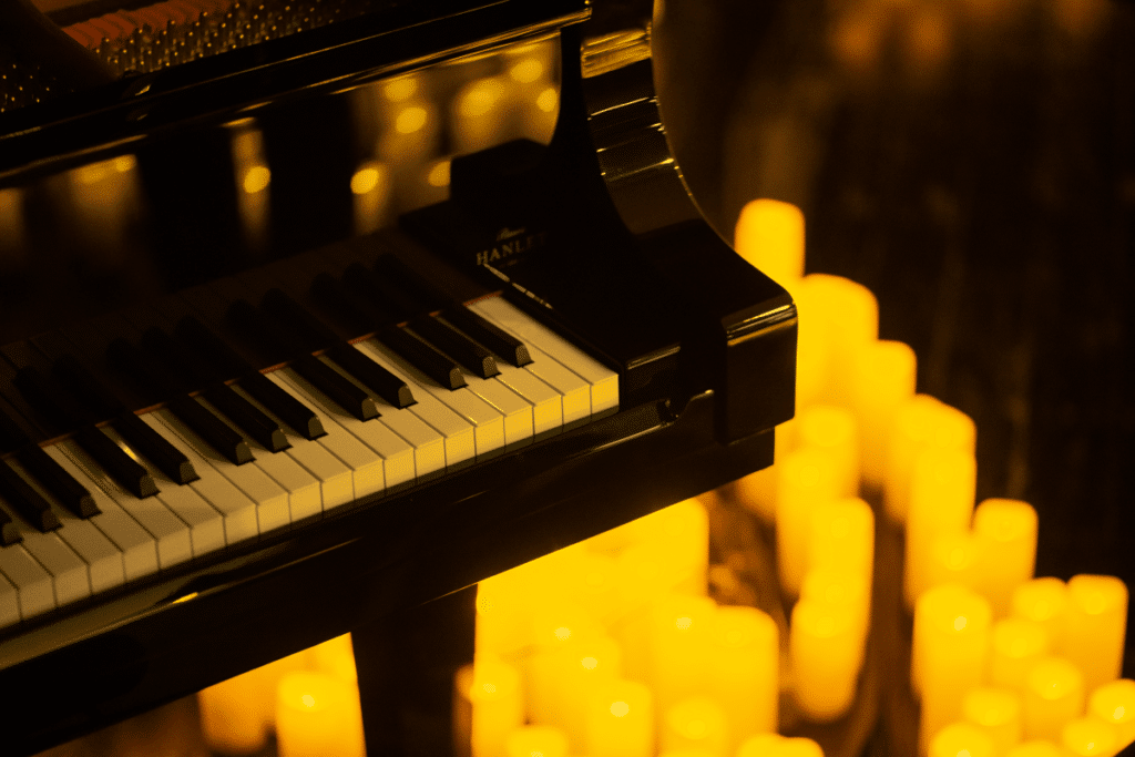 A close up of a grand piano with candles underneath it